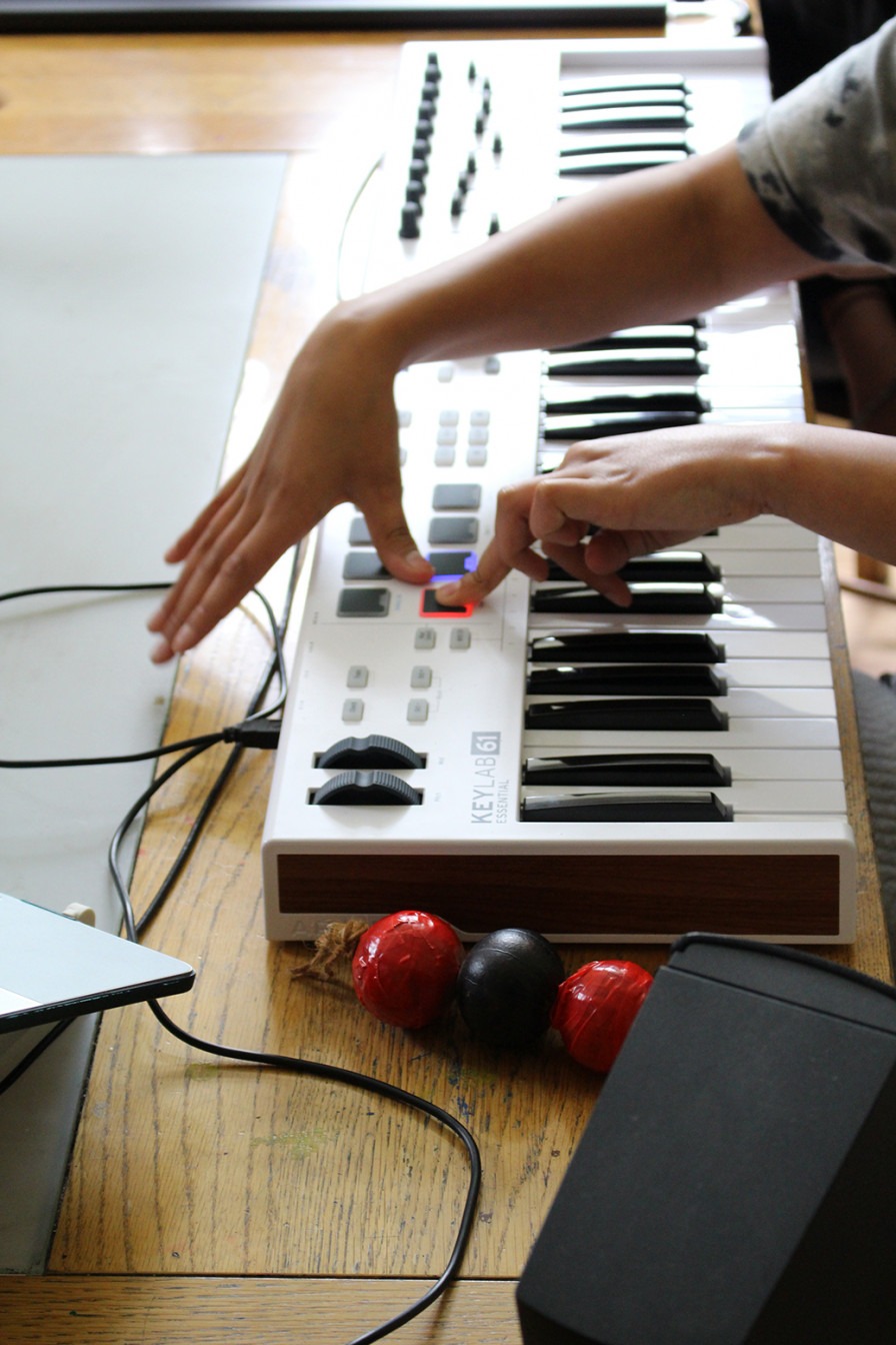 a student presses buttons on a synthesiser