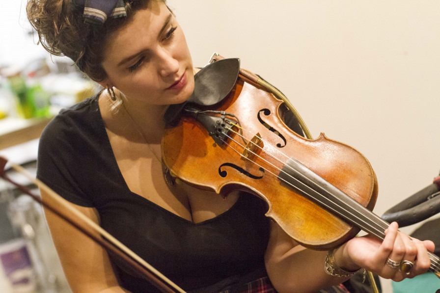 A young person plays a violin