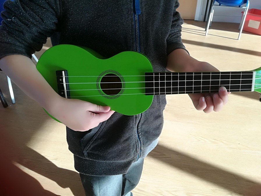 child playing green ukelele 
