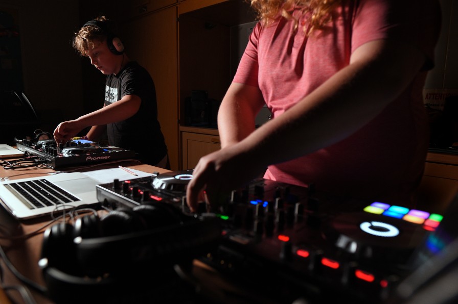 Two young people intensely focused on their DJ decks