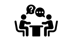 Icon of two people sitting down at a table, one asking a question and one answering it