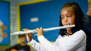 Young girl playing the flute.